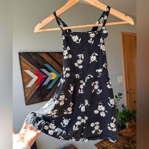 Trendy and comfortable girls 7/8 black rayon romper with daisies.